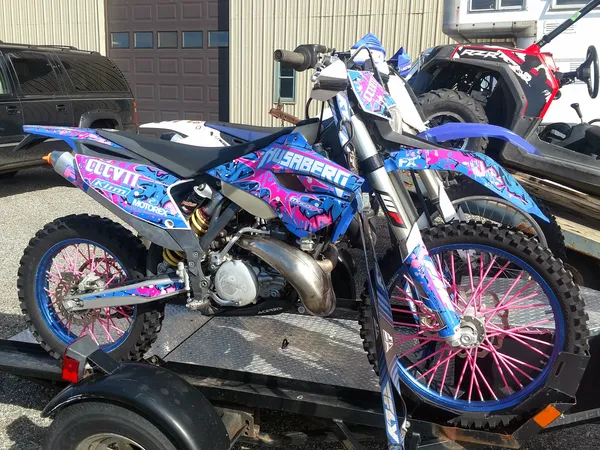 A Husaberg with a blue, white and pink Graffiti Custom Vinyl Wrap